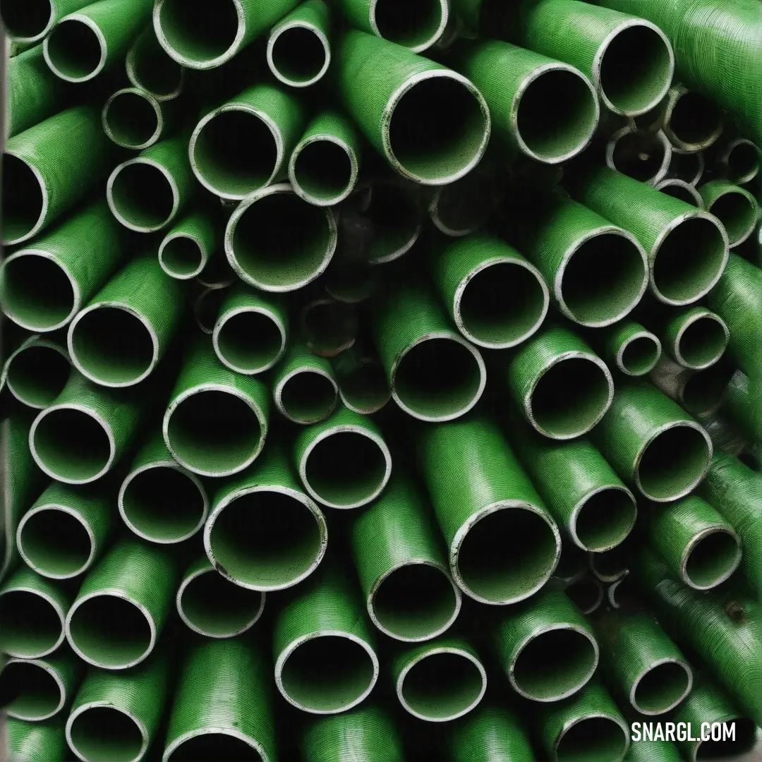 Pile of green pipes stacked on top of each other in a pile on the ground in a room. Example of RGB 25,89,5 color.