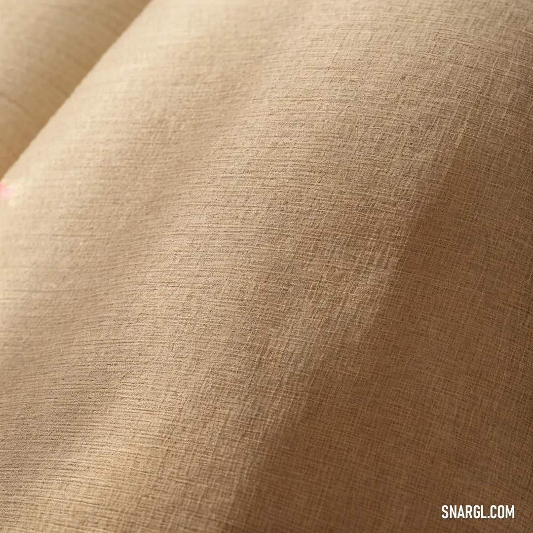 Close up of a tan fabric with a pink flower on it's side