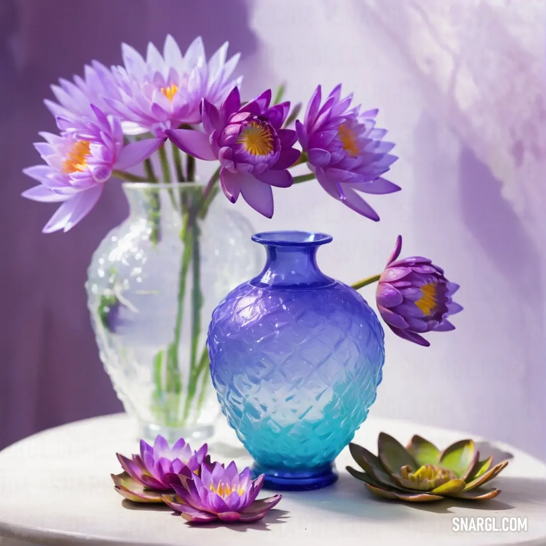 Blue vase with purple flowers in it on a table next to a white vase. Color Majorelle Blue.