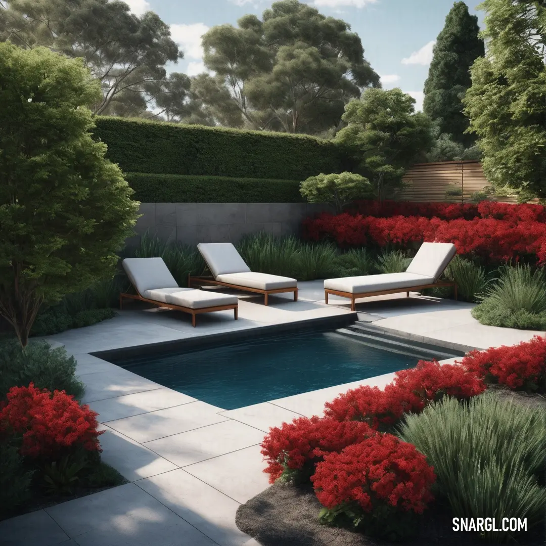 Pool surrounded by a lush green garden and red flowers and trees with a lounge chair next to it. Example of Maroon color.