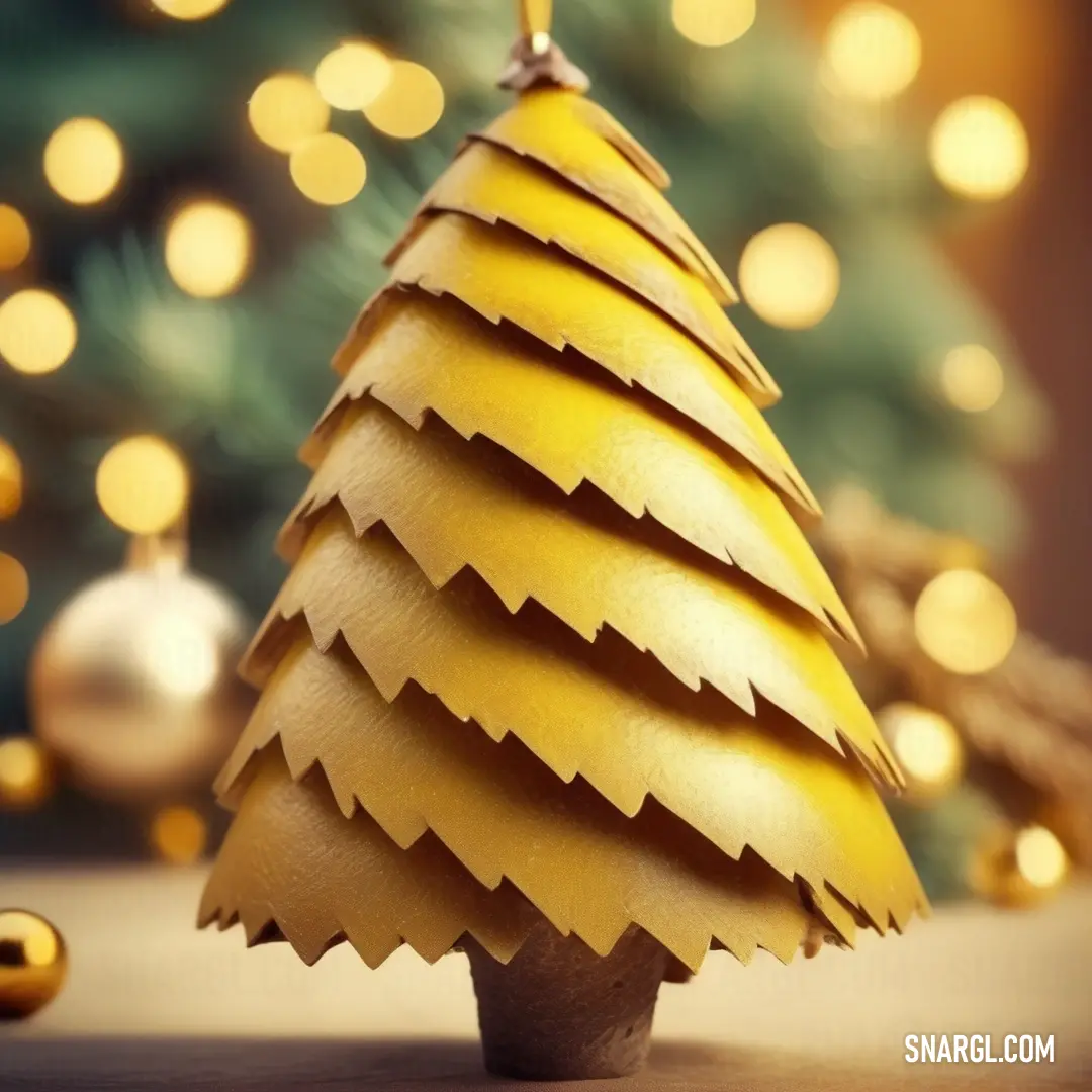 Small wooden christmas tree with a gold decoration on top of it. Example of #E5B73B color.