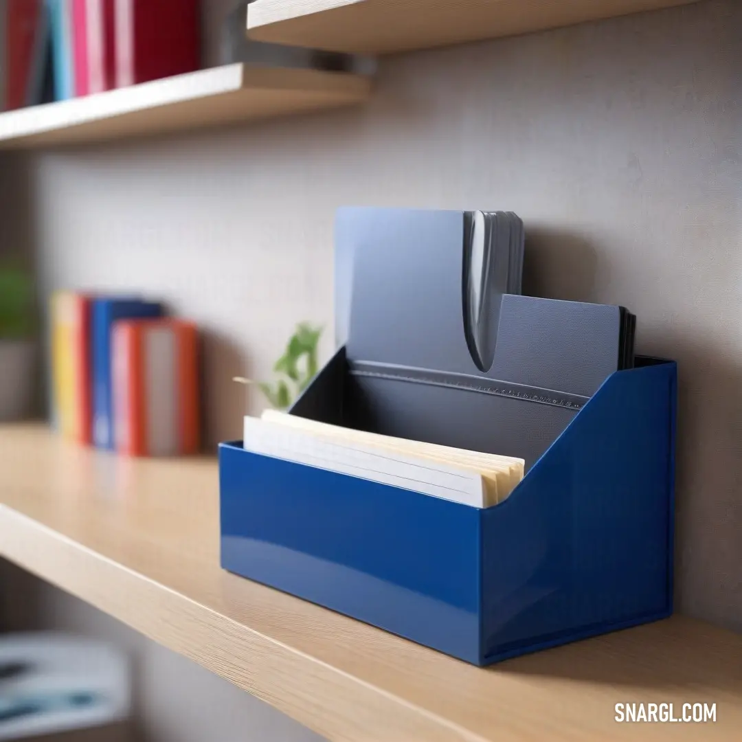 Blue file box on a shelf with a file folder in it and a knife sticking out of it. Color Medium electric blue.