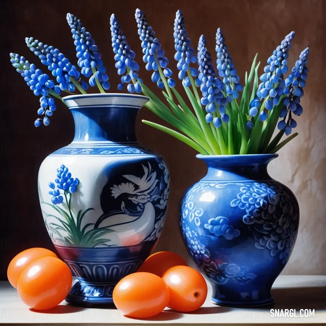 Painting of blue and white vases with orange balls in front of them and a blue flower arrangement in the middle