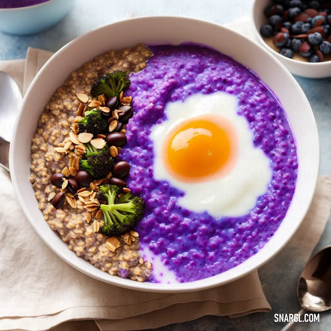 Bowl of oatmeal with a fried egg on top of it and a bowl of berries