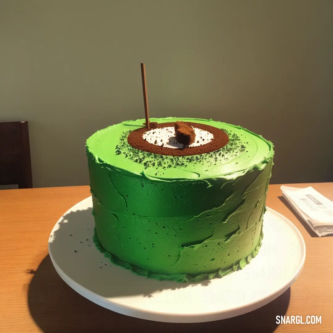 Green cake with a hole in the middle on a plate on a table with a notepad and a pen