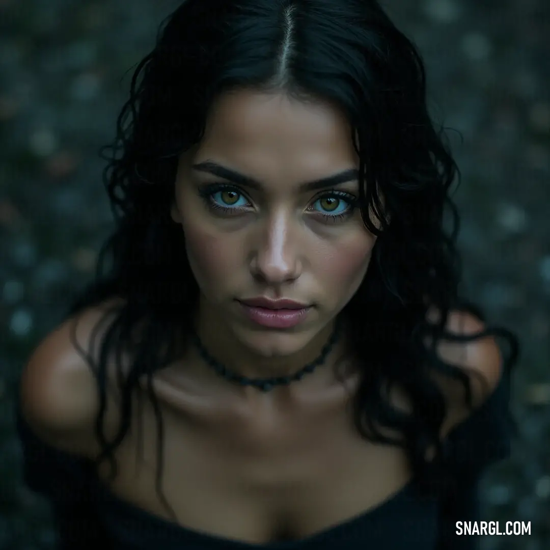 A striking portrait highlighting vivid blue eyes against a dark backdrop, revealing a bold, captivating spirit. A captivating portrait of a young woman with striking blue eyes, wearing a sleek black top against a rich, dark background, creating a bold contrast that highlights her features and the depth of her gaze.