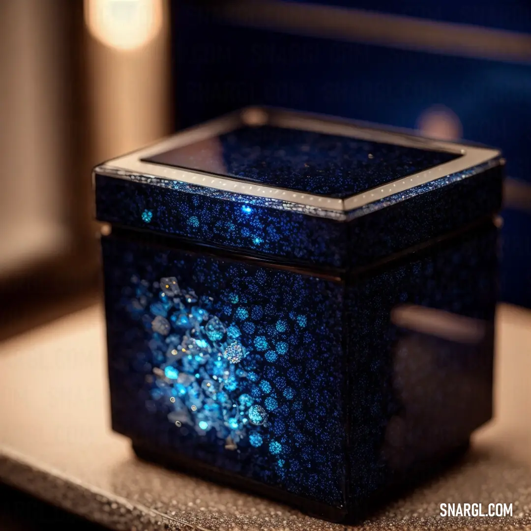 Blue box with a blue light inside of it on a table next to a window