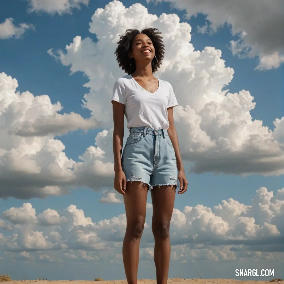 Woman standing on a beach with clouds in the background
