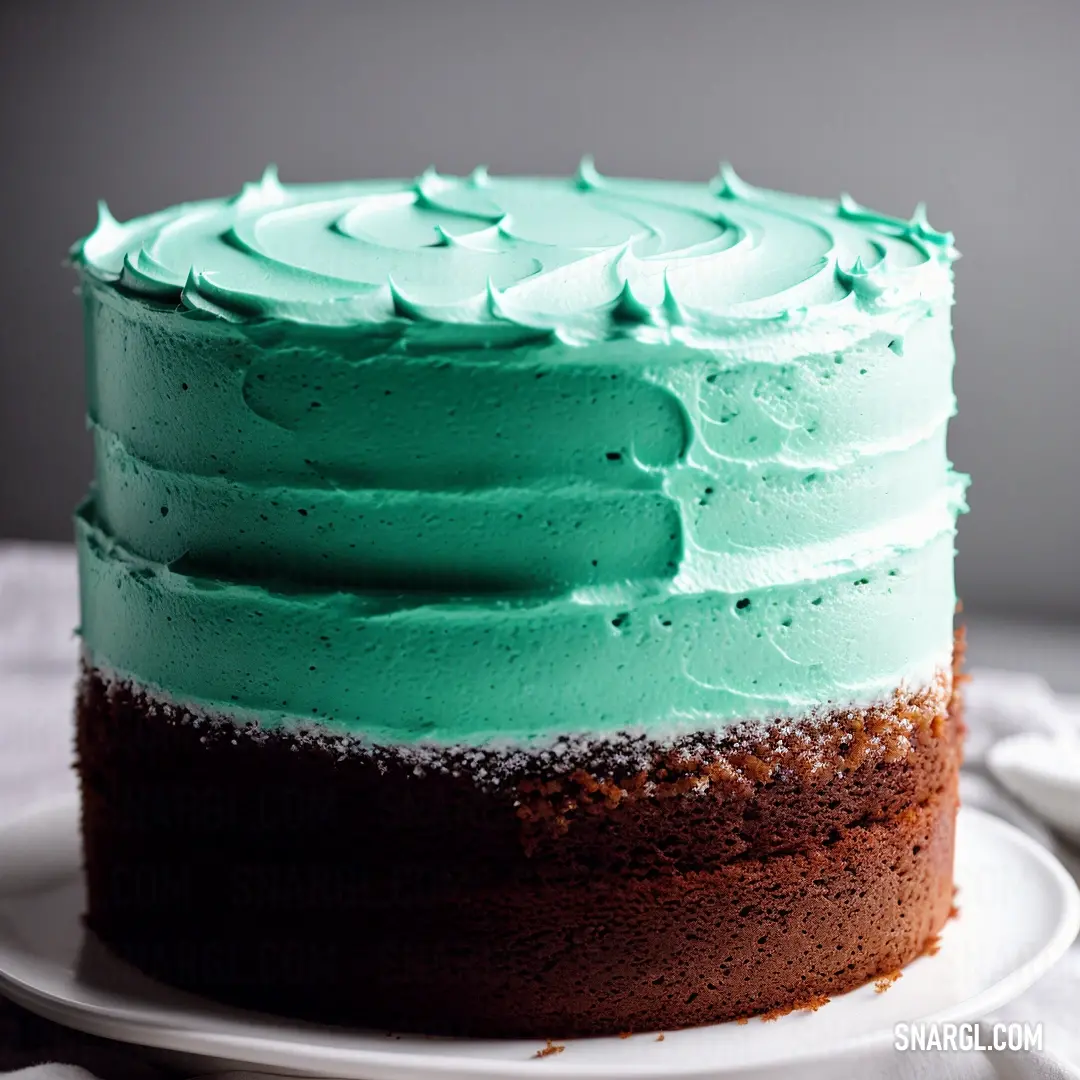 Cake with green frosting on a plate on a table with a napkin and fork next to it
