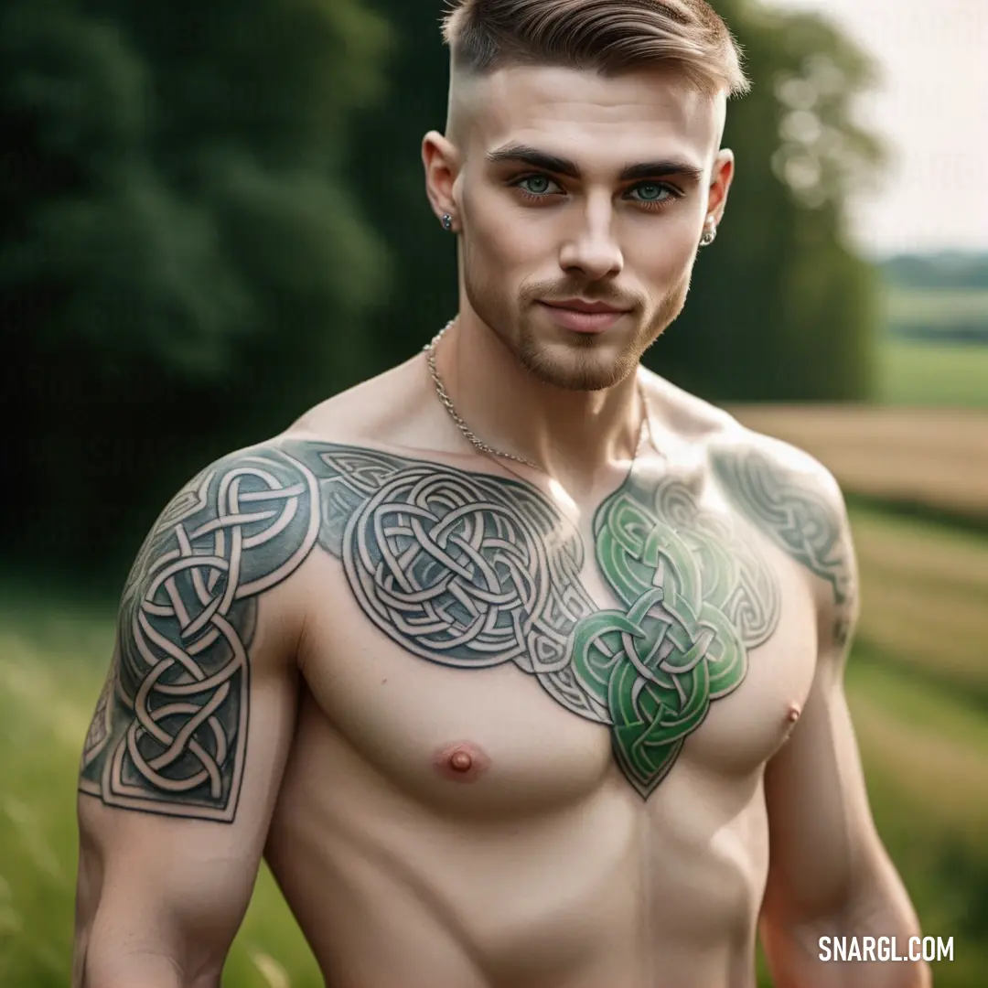 Man with a tattoo on his chest and chest standing in a field of grass with trees in the background. Color MSU Green.