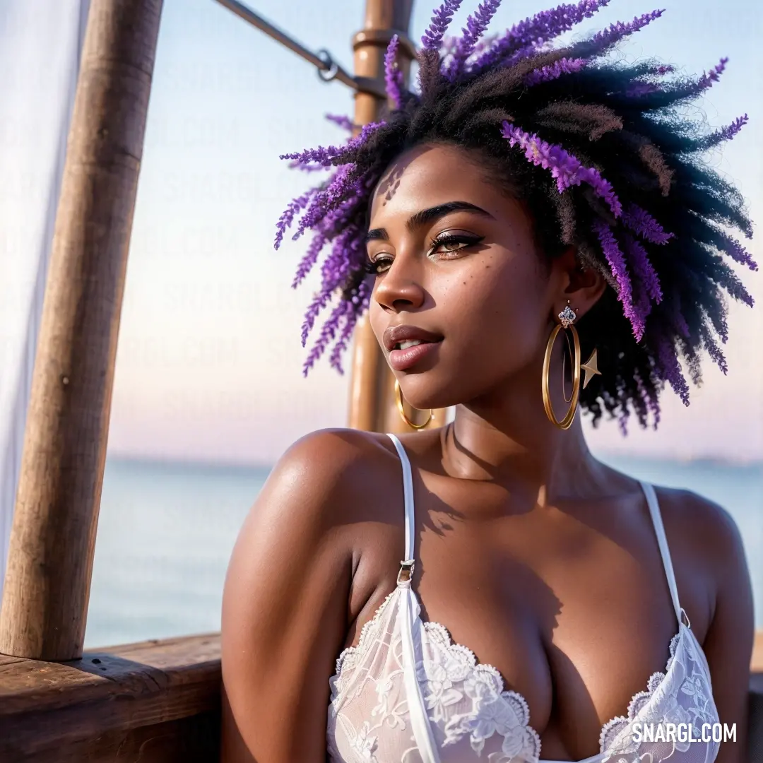 Woman with a purple dreadlocks is posing for a picture by the ocean with her bra