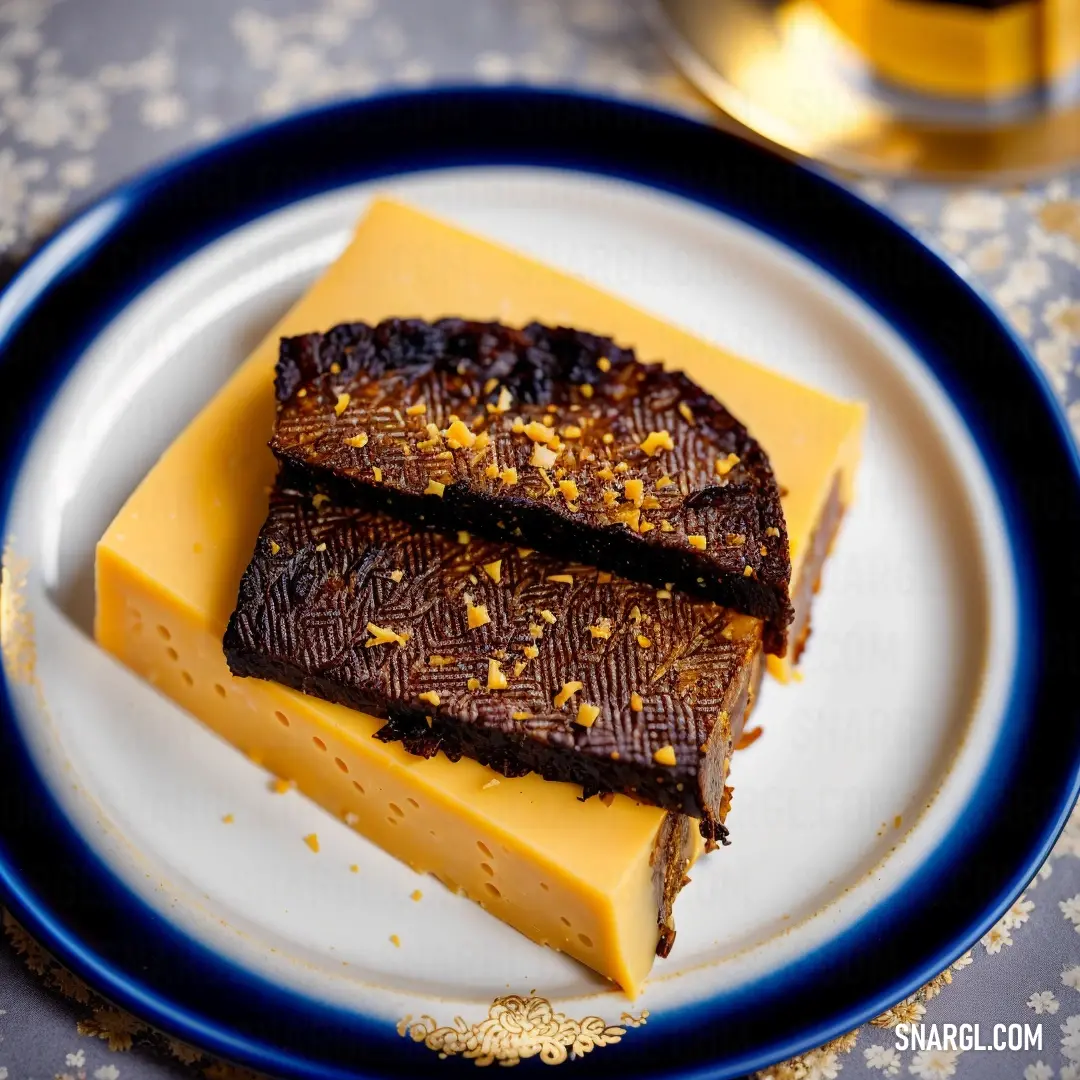 Plate with two pieces of chocolate and a piece of cheese on it with a blue rim on a table