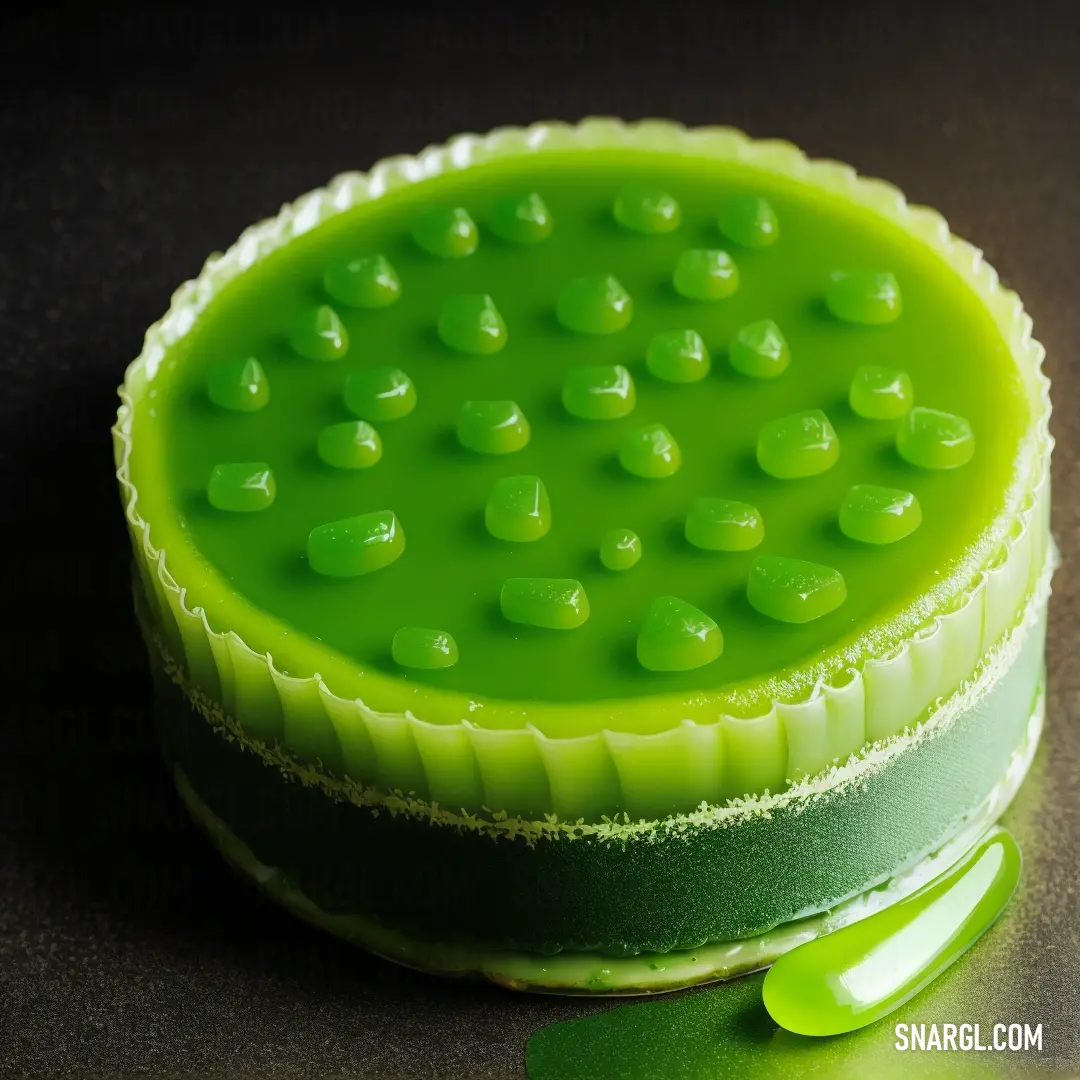 Green cake with a green spoon on a table with a black background and a green background