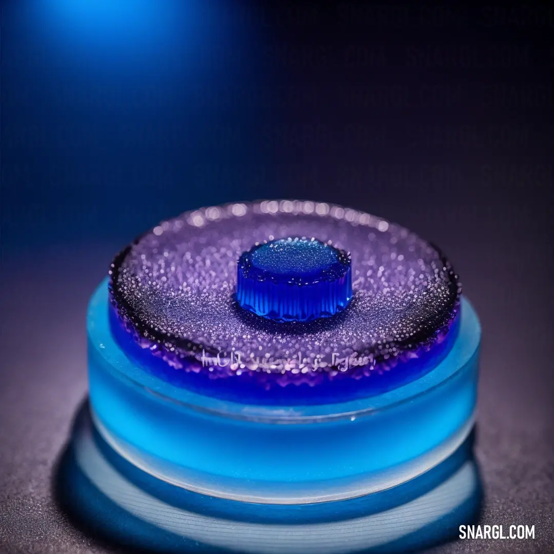 Blue glass container with a blue lid on a table top with a blue light behind it