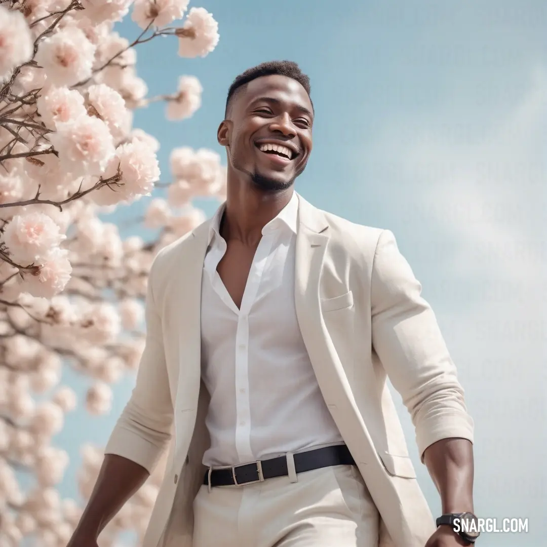 Man in a white suit and white shirt is smiling while standing in front of a flowering tree. Color RGB 255,246,247.