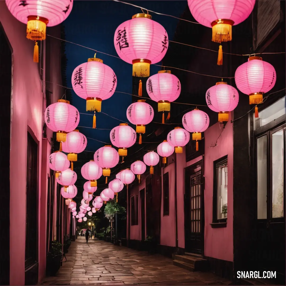 Street with pink lanterns hanging from the ceiling and a person walking down the street in the distance on the sidewalk
