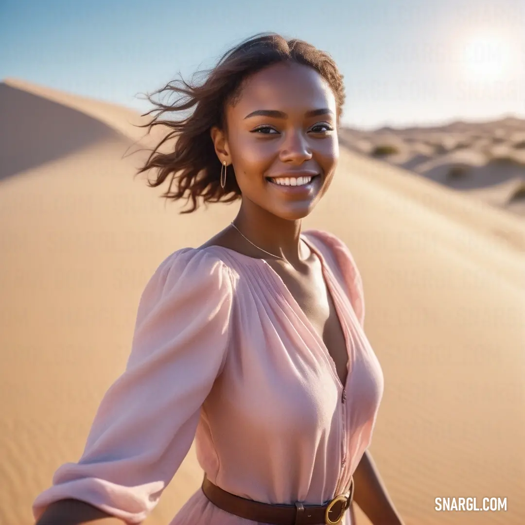 NCS S 0520-R10B color. Woman in a pink dress standing in the desert with her hair blowing in the wind and smiling at the camera