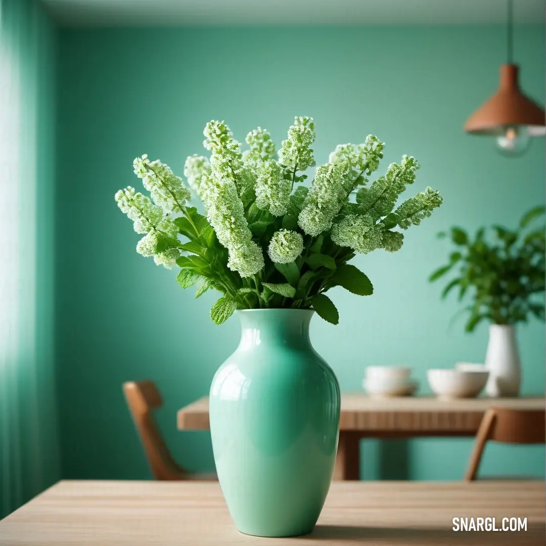 Vase with some flowers in it on a table in a room with a green wall. Color CMYK 40,0,40,0.