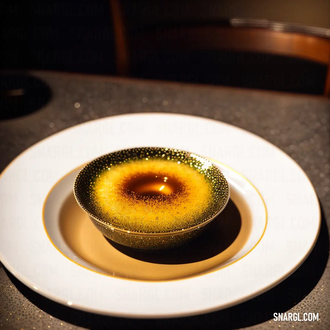 A small bowl with a lit candle rests on a delicate plate atop a table. In the background, a chair stands quietly. The warm orange hue of the candle complements the soft atmosphere.