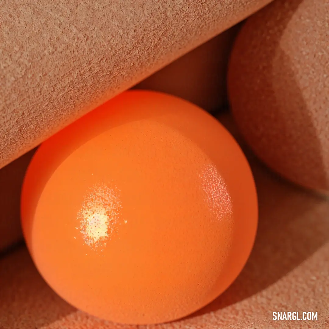 Orange ball is in a corner of a wall with a tan background. Color #F77F44.
