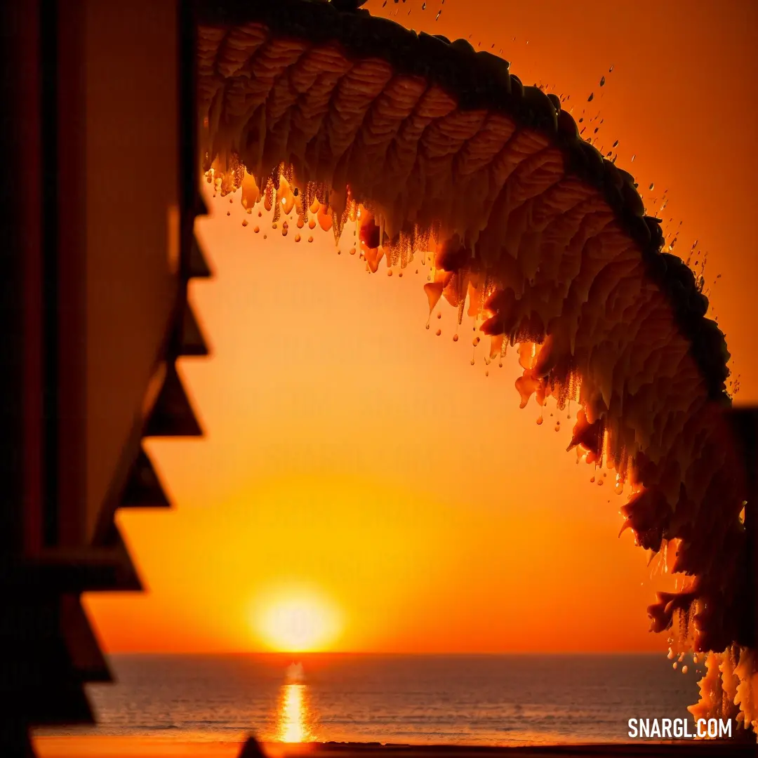 A serene sunset over the ocean, viewed from a balcony of a resort in India. The warm, golden tones of the setting sun reflect across the water, casting a peaceful glow over the entire scene. The tranquil colors evoke a sense of calm and beauty.