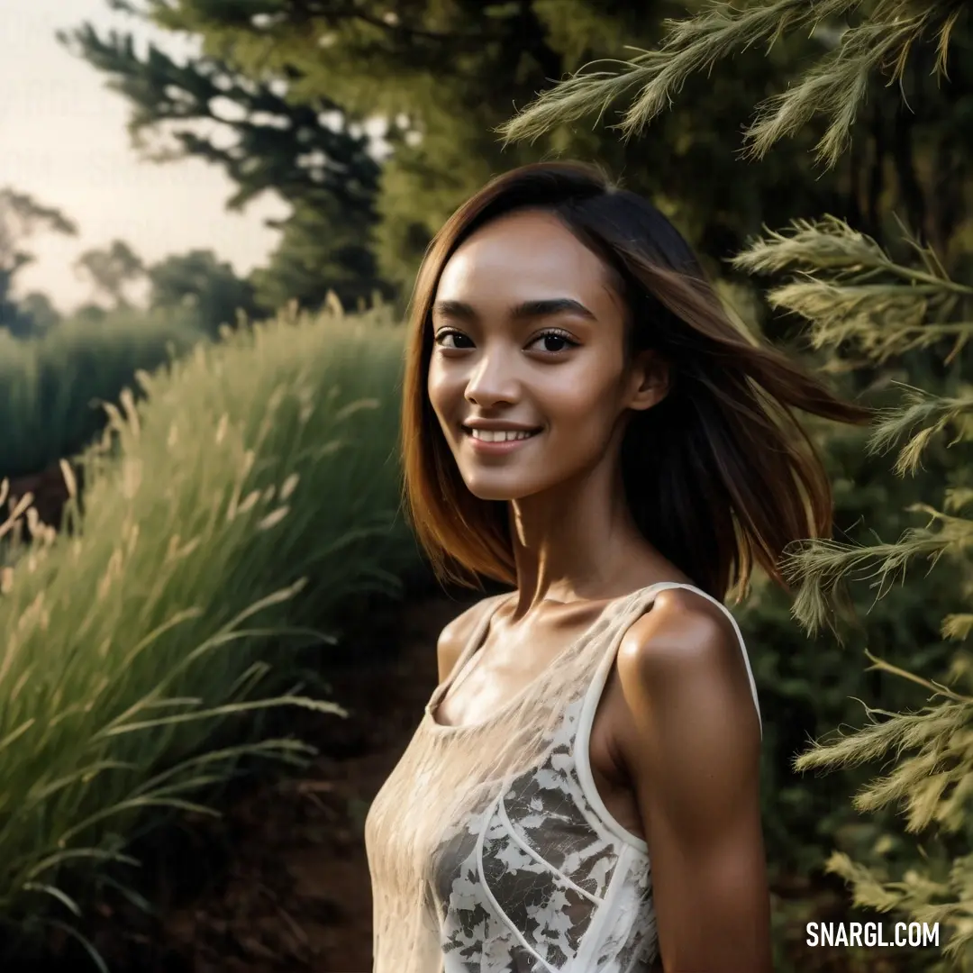NCS S 1000-N color. Woman standing in front of a bush with her hair in the wind and smiling at the camera