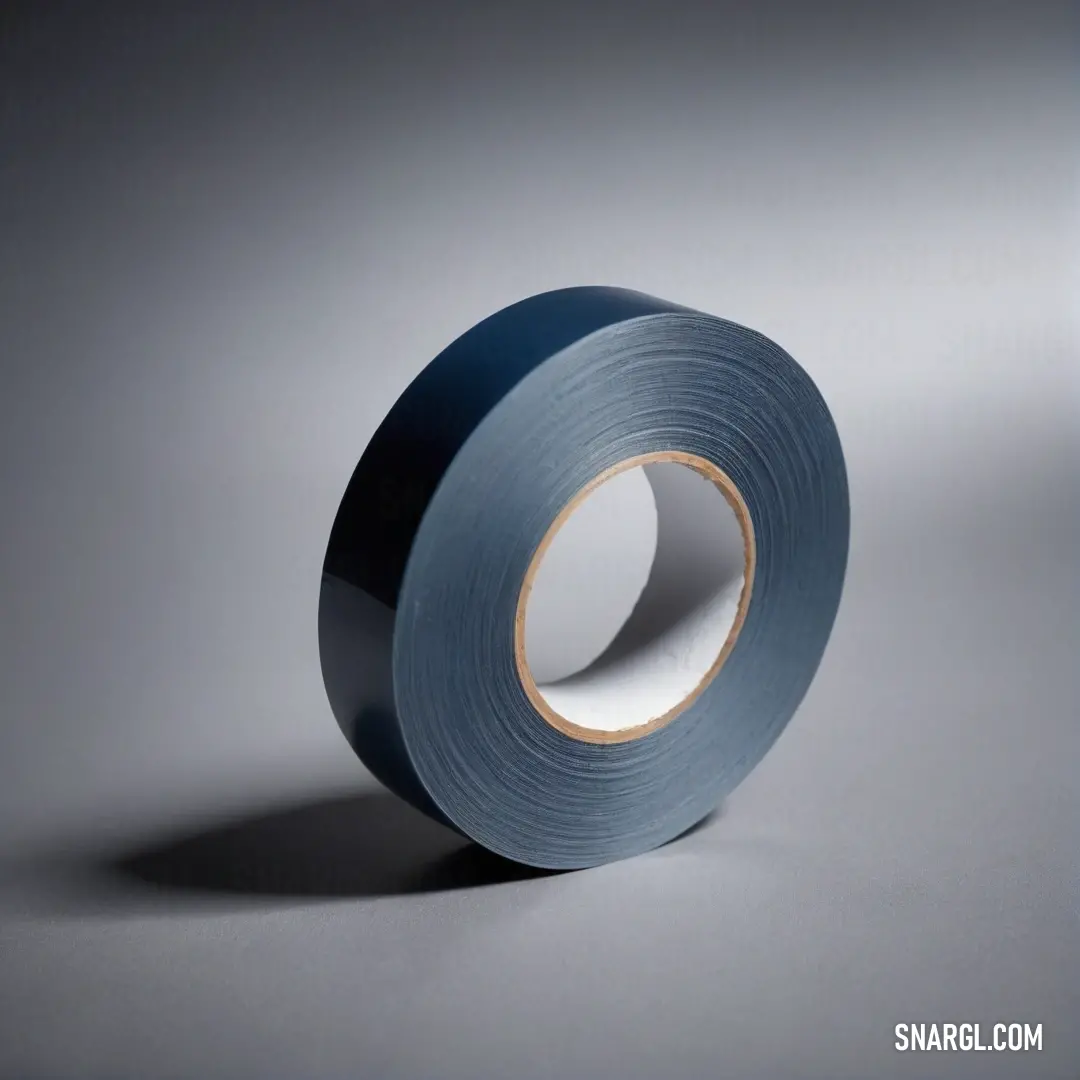 A vibrant roll of blue tape rests on a textured gray surface, casting a shadow that adds depth to the image. The interplay of light highlights its smooth, shiny surface, offering a moment of intrigue in the midst of simple everyday objects.