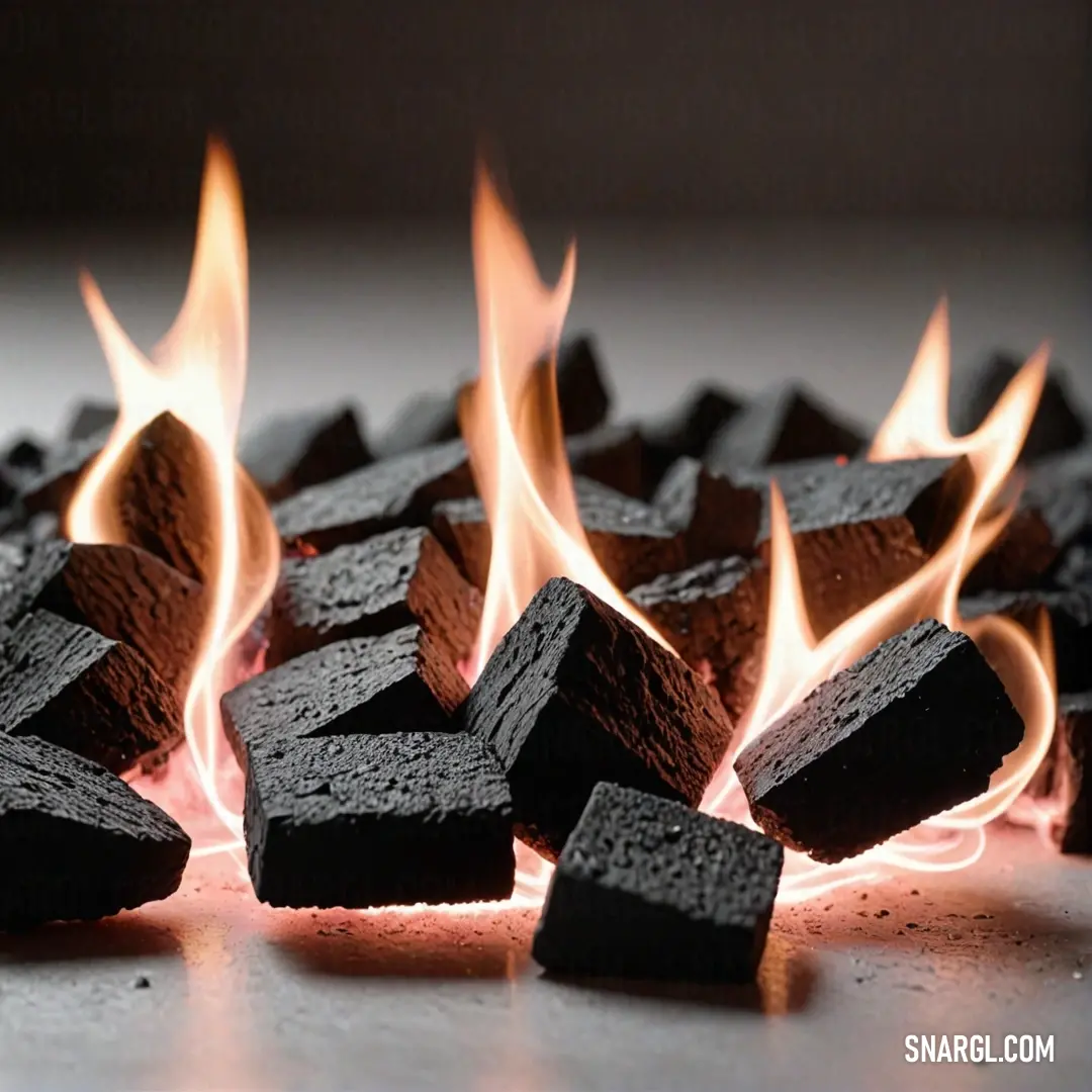 A dramatic scene of black wooden blocks ablaze, with vibrant flames leaping from the surface on a rustic tabletop. The contrasting colors of dark wood and orange flames captivate the viewer, evoking a sense of warmth and intensity.