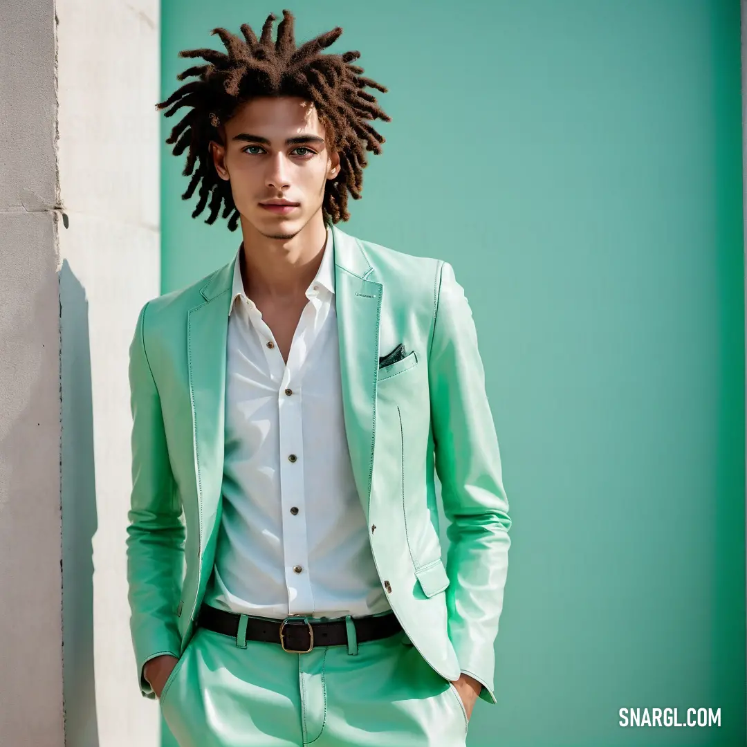 NCS S 1040-B80G color. Man with dreadlocks in a green suit and white shirt standing in front of a wall wearing a green suit