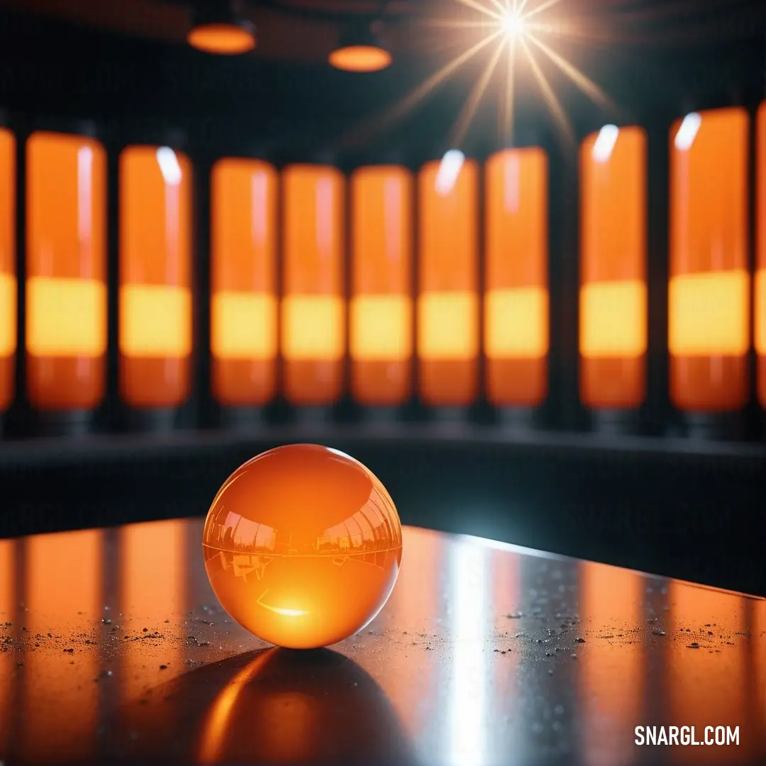 Shiny orange ball on a table in a room. Example of NCS S 1050-Y20R color.