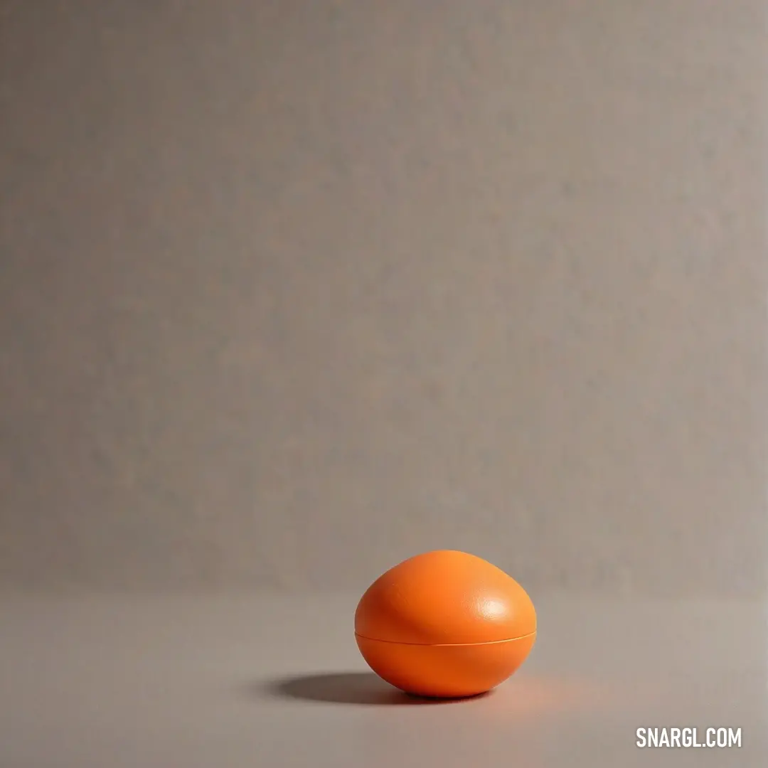 A vibrant orange object sitting confidently on a clean table against a pure white background, evoking a feeling of brightness and simplicity intertwined with elegance.