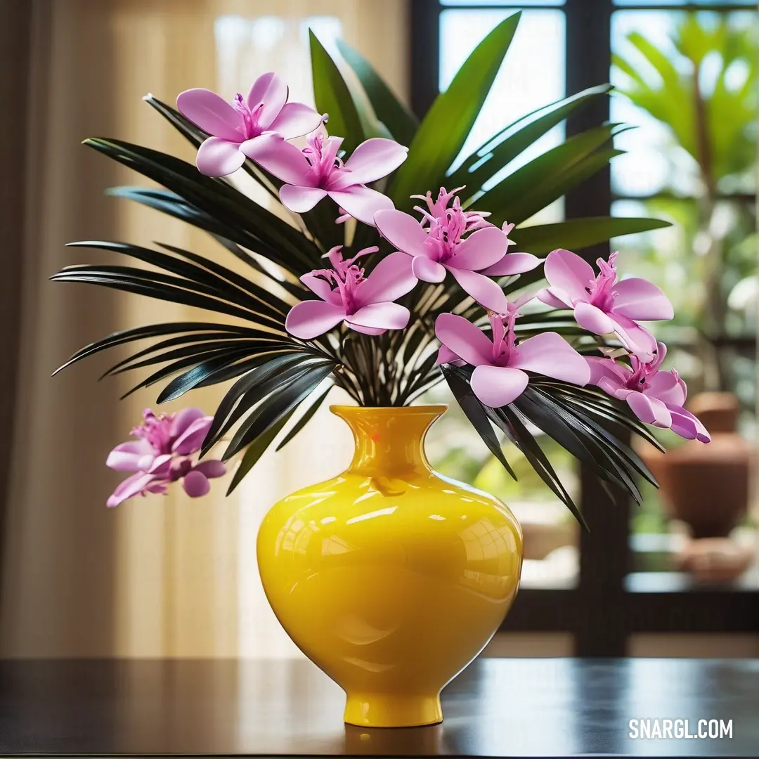 Yellow vase with pink flowers on a table in front of a window with a large plant in it. Color RGB 236,188,0.