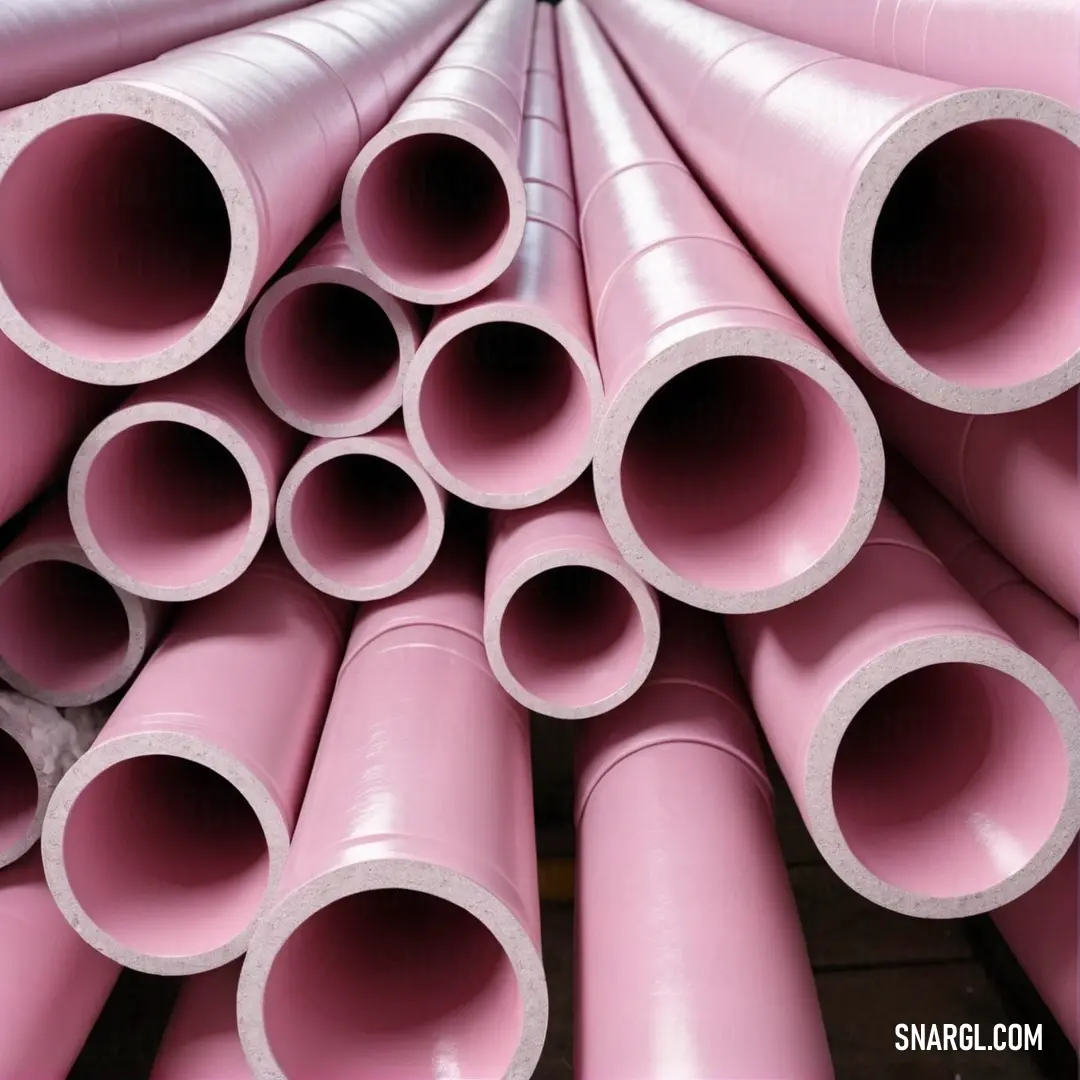 A visually appealing scene showing a stack of pink pipes placed on top of each other in a warehouse against a dramatic black background, highlighting the contrast between materials and colors.