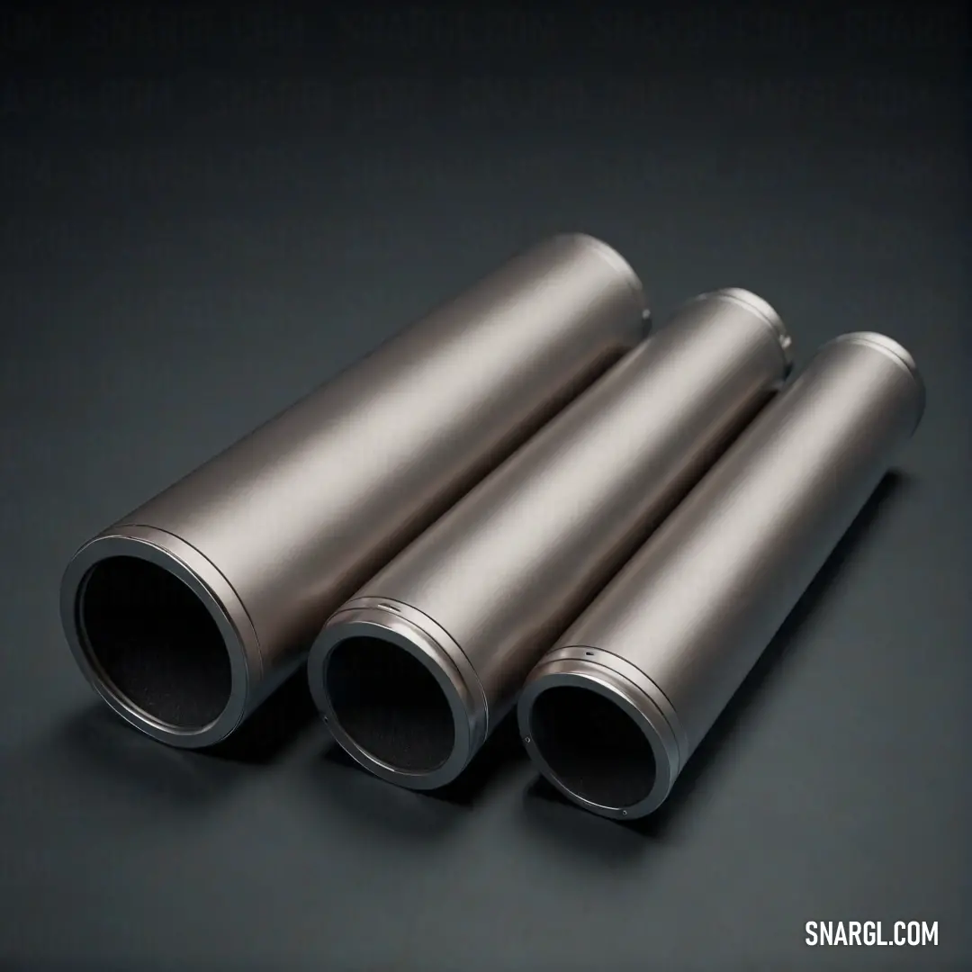 Three gleaming silver tubes rest elegantly on a dark surface, reflecting light in a mesmerizing display. The juxtaposition between the sleek metal and the muted background draws attention to their design, sparking curiosity about their function and origin