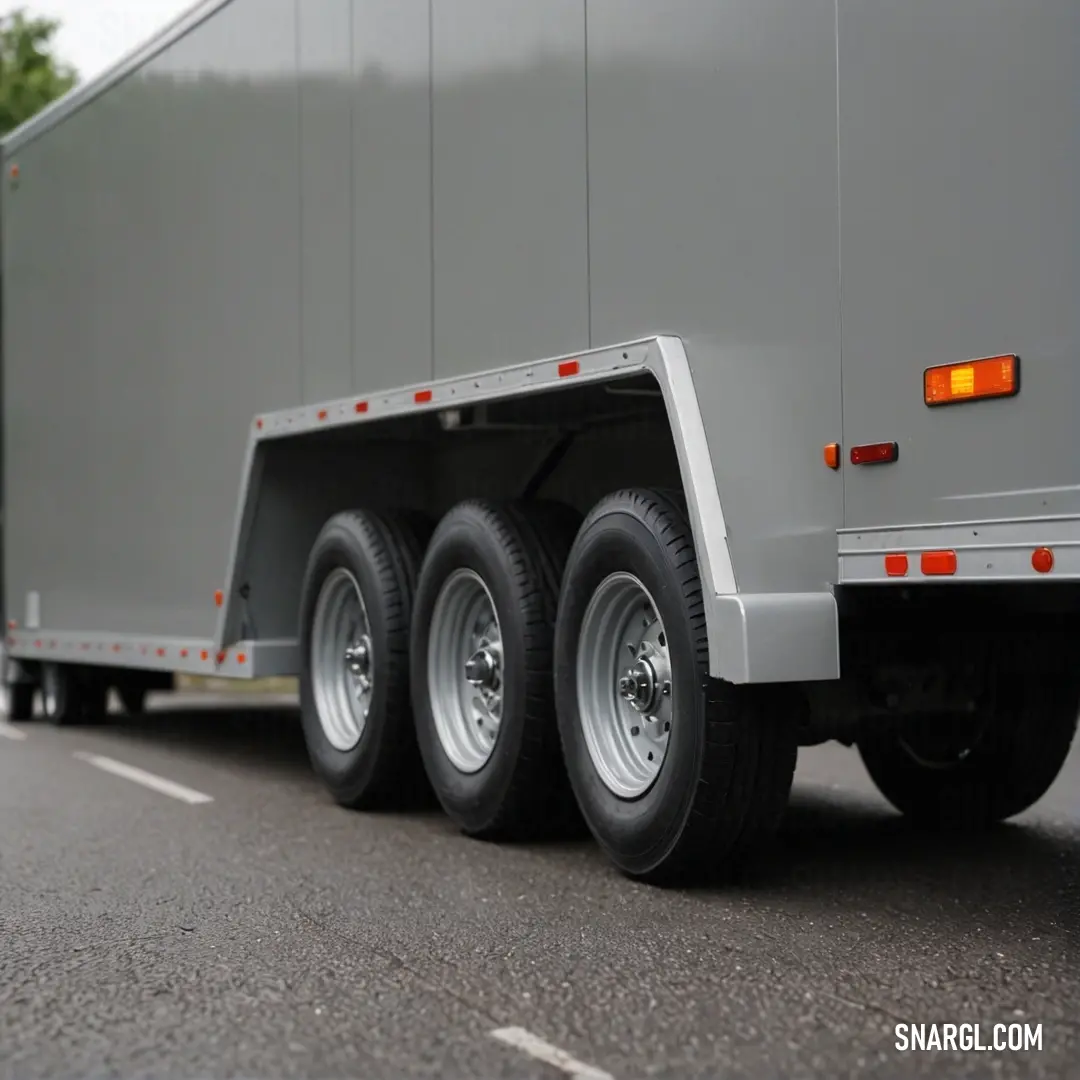 A powerful semi-truck pulling a sleek trailer makes its way along a smooth highway, surrounded by lush greenery that enhances its striking contrast. The soft hue of the truck glimmers under the sunlight, showcasing its strength and purpose.