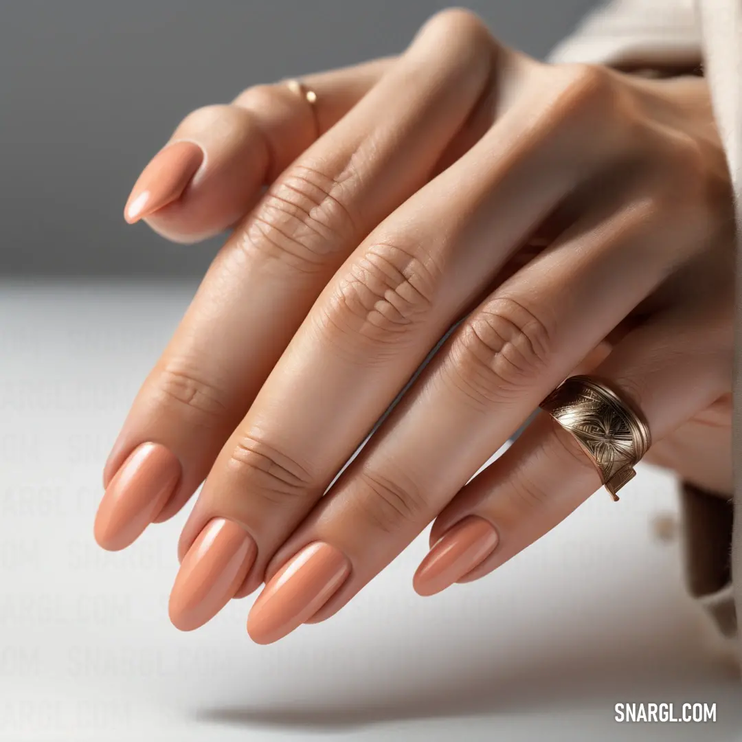 Woman's hand with a ring on it and a ring on her finger. Example of #F0C5B3 color.