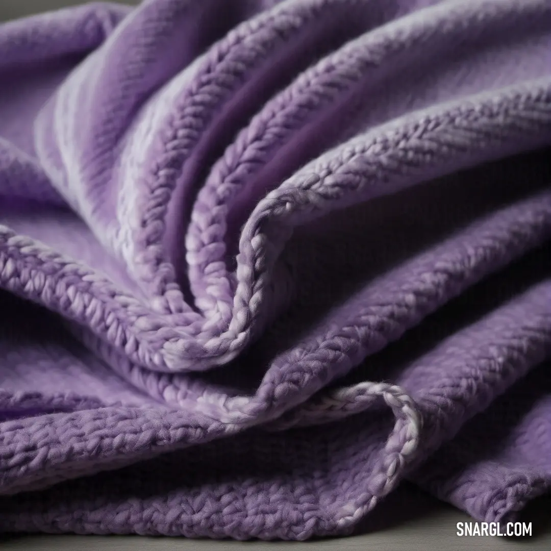NCS S 2020-R60B color. Purple blanket is folded on a bed with a white pillow on top of it