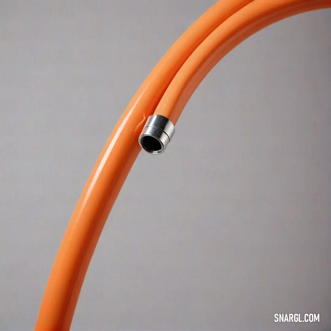 A vibrant close-up of an orange hose featuring a sleek black end, elegantly contrasted against a soft gray backdrop, creating a pleasing visual harmony. The color exudes warmth and energy, drawing attention to its textured surface.