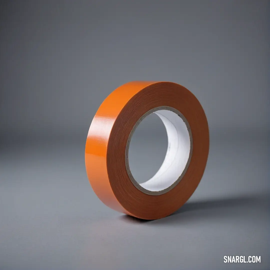 A vibrant roll of orange tape rests against a textured grey backdrop, showcasing its rich hue. The tape's glossy finish contrasts beautifully with the understated background, making it a striking centerpiece.