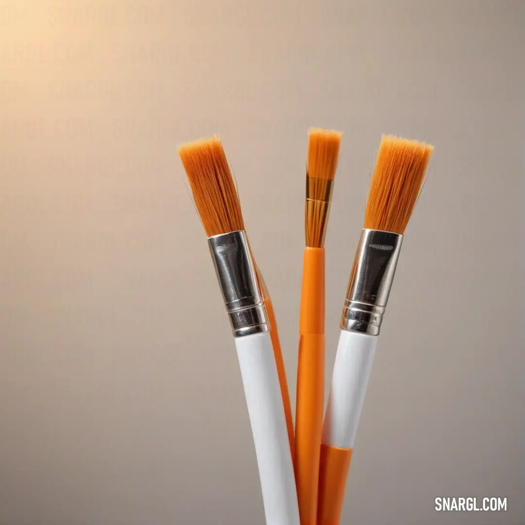 An artistic display featuring two orange and white paintbrushes nested within a transparent glass container, illuminated by soft light that enhances their vibrant colors, showcasing the interplay between tools and artistry in a tranquil atmosphere.