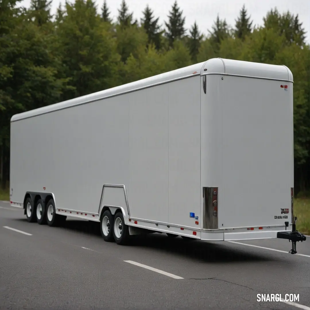 A sleek white trailer cruising down a scenic road, flanked by lush trees and bushes under a canvas of clouds, invoking a sense of freedom and exploration on a beautifully dynamic day.