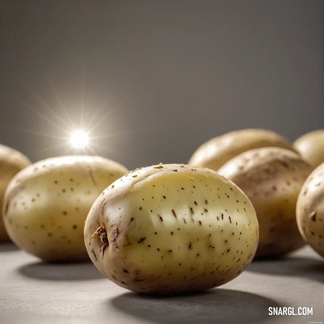 A stunning arrangement of potatoes illuminated by light, showcasing their NCS S 4030-Y color against a wooden table backdrop. This image captures their natural simplicity and the warmth of home cooking.