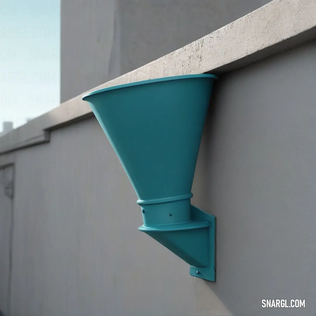 Hanging gracefully on a building's edge, a stunning blue vase contrasts beautifully against a brick wall, showcasing delicate craftsmanship while casting playful shadows in warm sunlight.