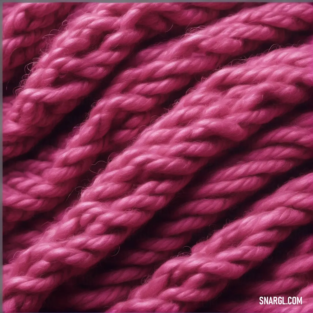 Close up of a pink yarn ball with a blue frame around it. Example of #7F2444 color.