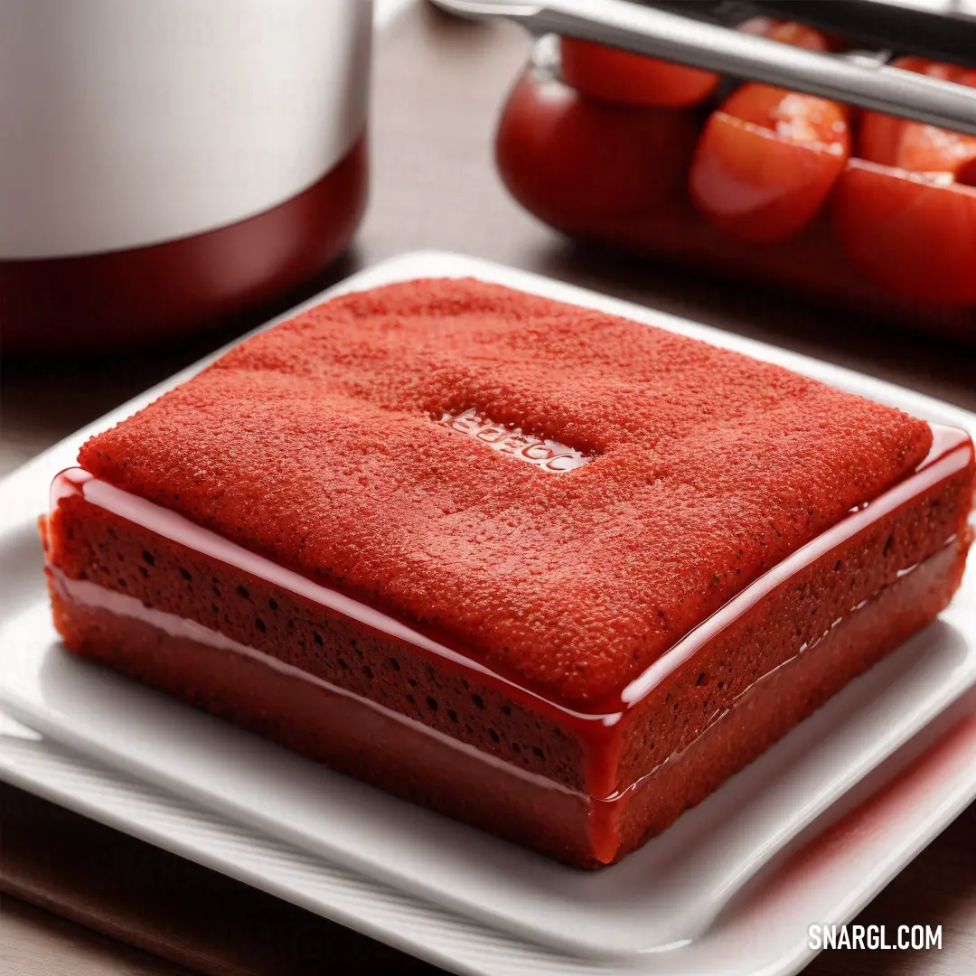 NCS S 4050-Y60R color example: Square red cake on a white plate on a table with a red container of tomatoes in the background