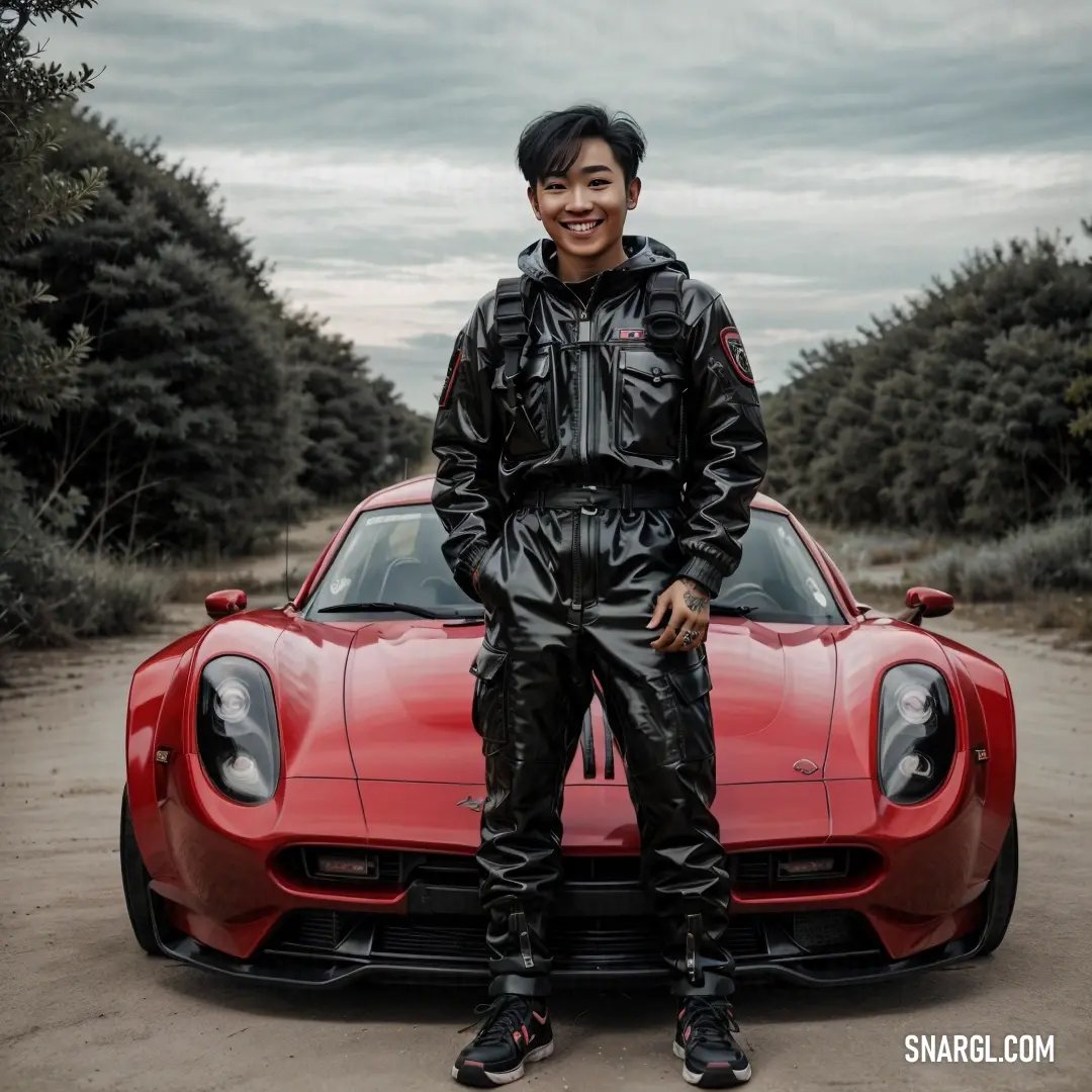 Man standing next to a red sports car in a dirt road with trees in the background. Example of RGB 107,14,18 color.