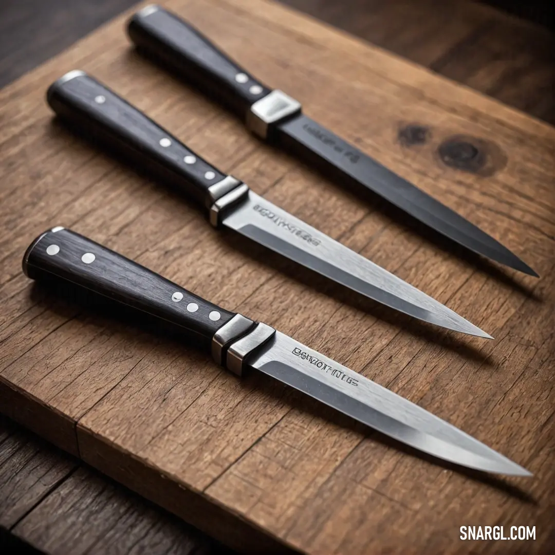 A meticulous arrangement of three knives on a wooden cutting board, featuring one knife prominently in the center. This visual emphasizes both functionality and aesthetic appeal found in high-quality kitchen tools.