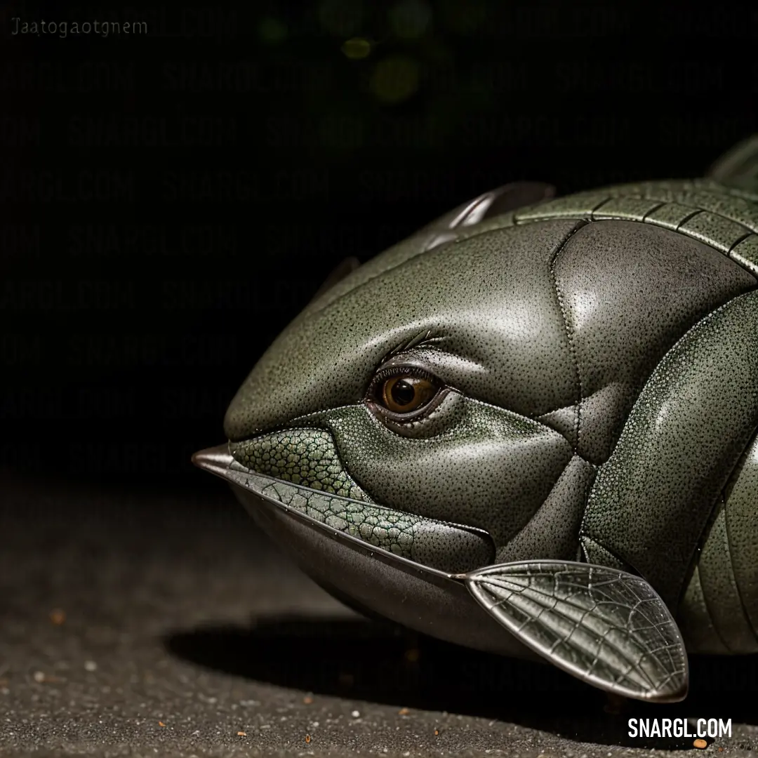 Fish statue is shown on the ground in the dark, with a black background. Example of #556058 color.