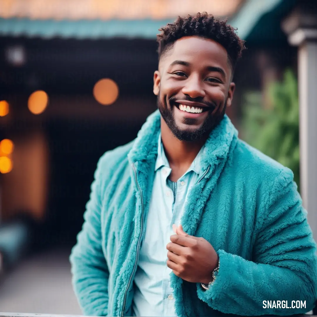 Man with a beard and a blue jacket smiling at the camera with a smile on his face