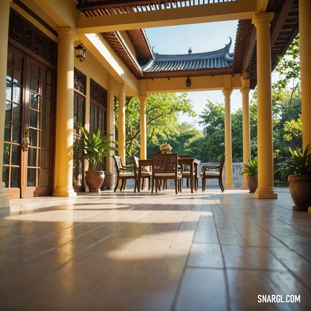 A cozy patio set with a table and chairs, with a potted plant adding a touch of greenery to the scene. The warm golden hues of the surroundings create an inviting atmosphere, making it a perfect spot for relaxation and outdoor dining.